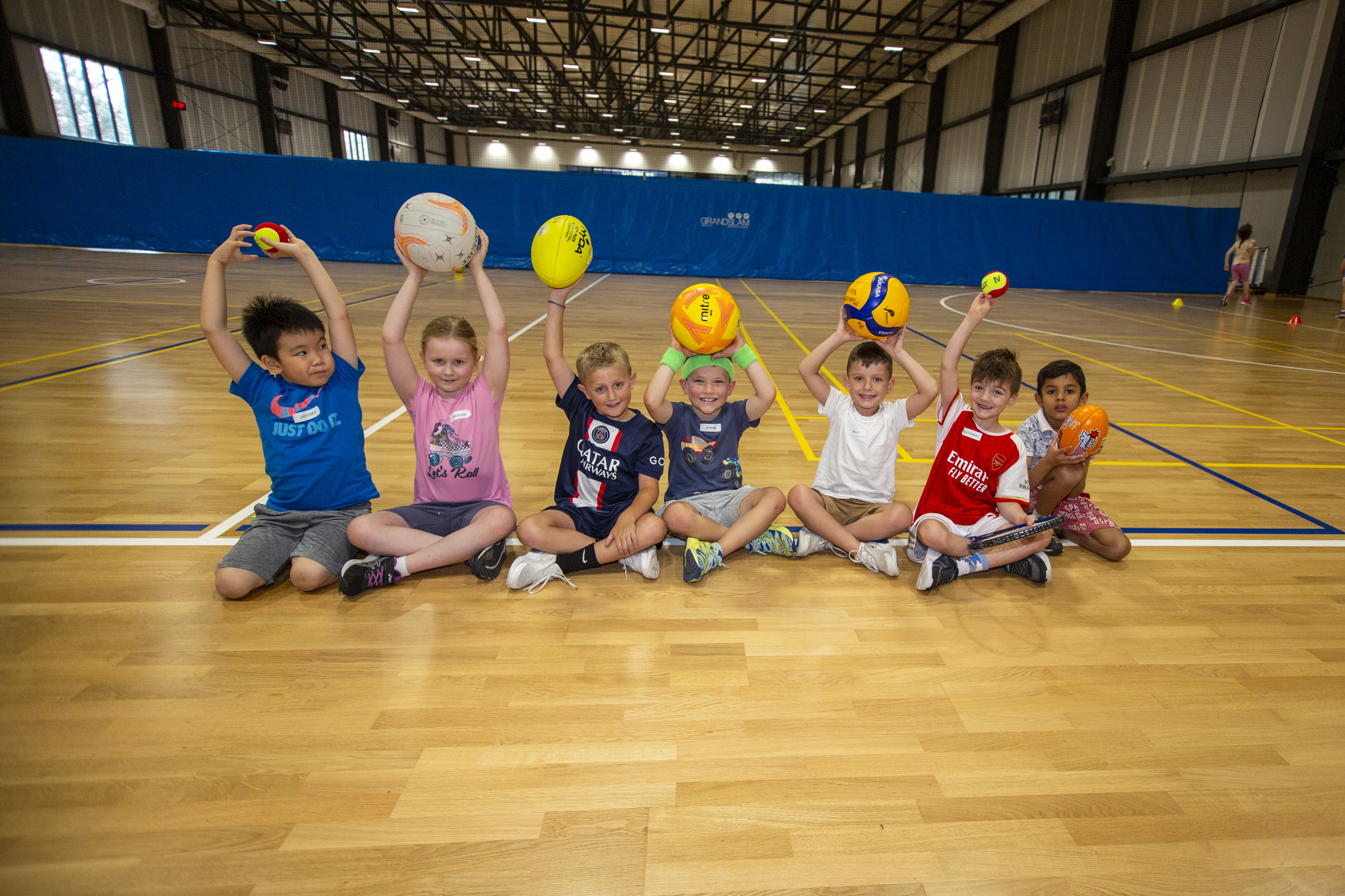 A group of children show the range of sports they enjoy in the school holiday programs