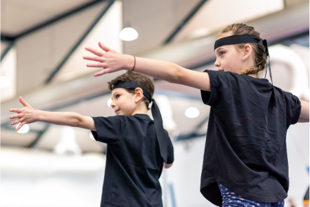 Ninja participants pretending to shoot bow and arrows