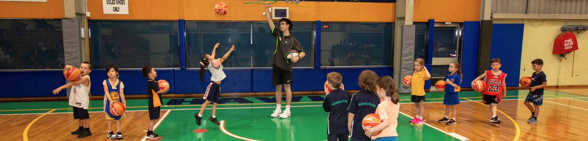 Junior basketballers lining up to practise throwing into a hoop