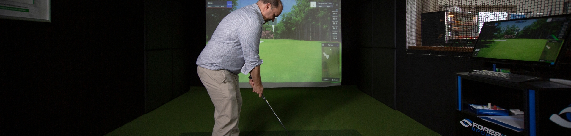 man playing golf on golf simulator