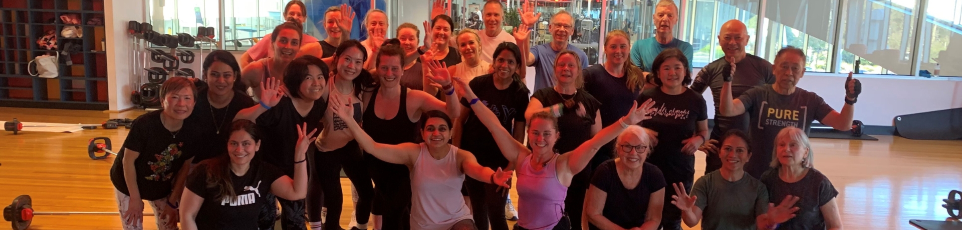 large group fitness class posing for joyful photo